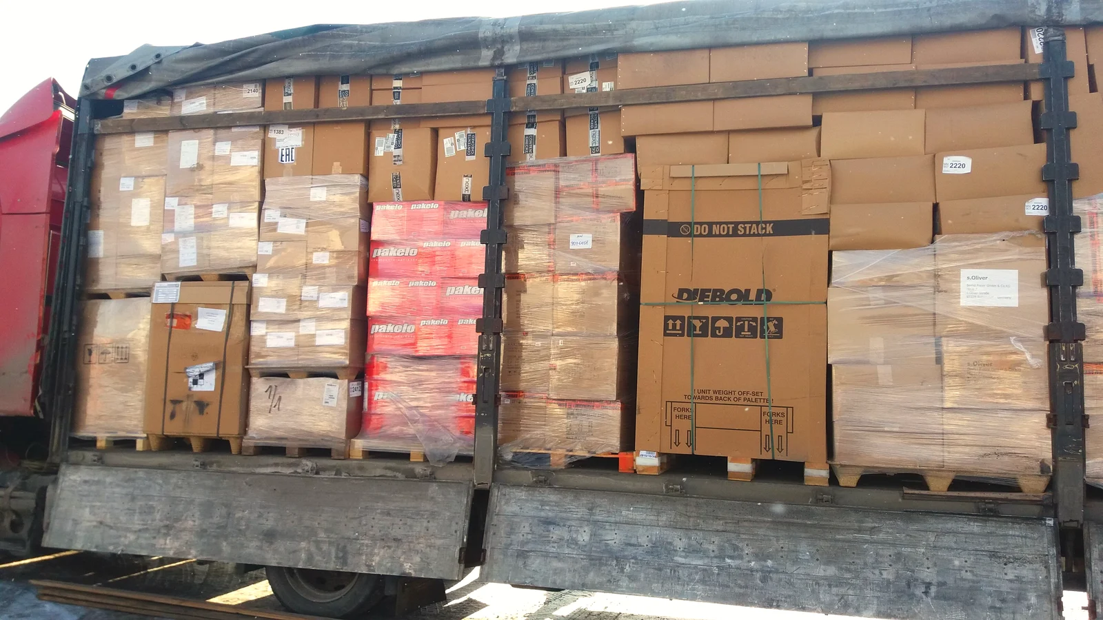 Curtain-sided LTL truck with shrink-wrapped pallets of boxes visible