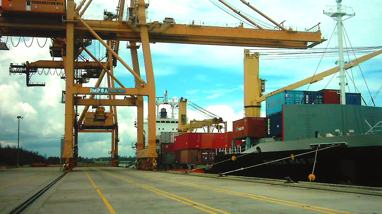 Container ship alongside a berth with quay cranes at Kuantan Port