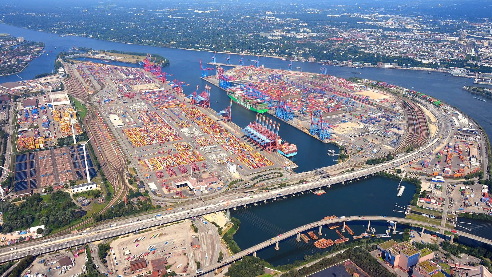 Aerial view of Hamburg container terminals with colourful stacks, ships and river