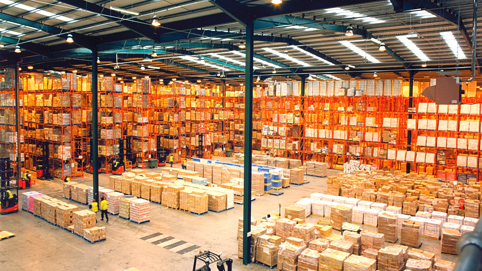 Large warehouse with pallet racking and palletised goods on the floor