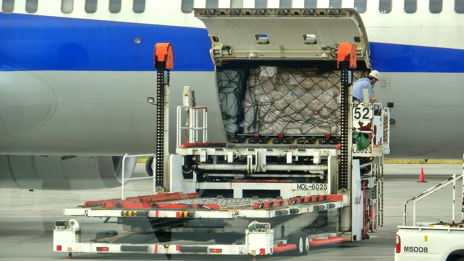 Air cargo container being loaded into a Boeing 777 at an airport