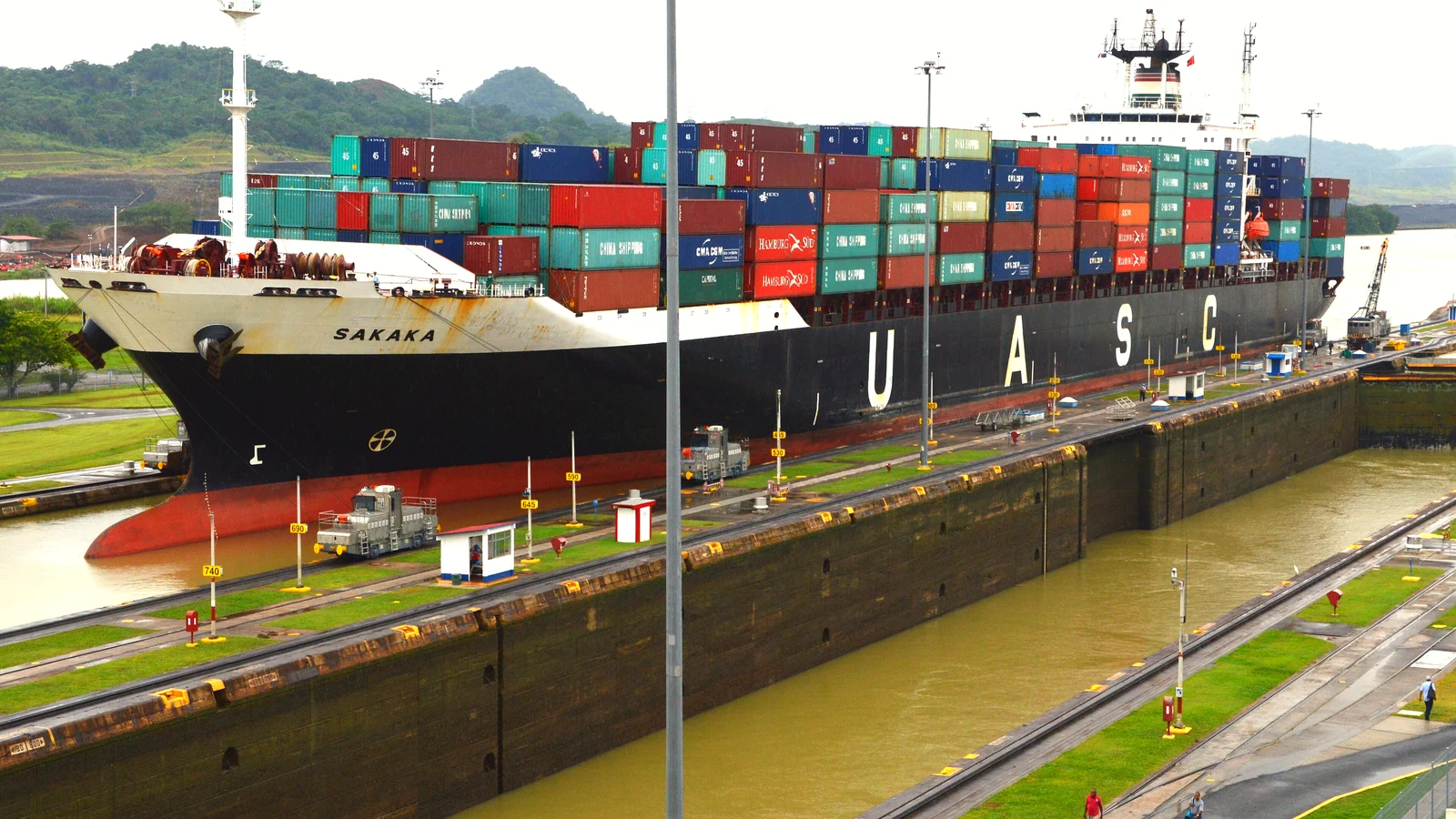 Container ship in the Miraflores Locks of the Panama Canal with lock locomotives