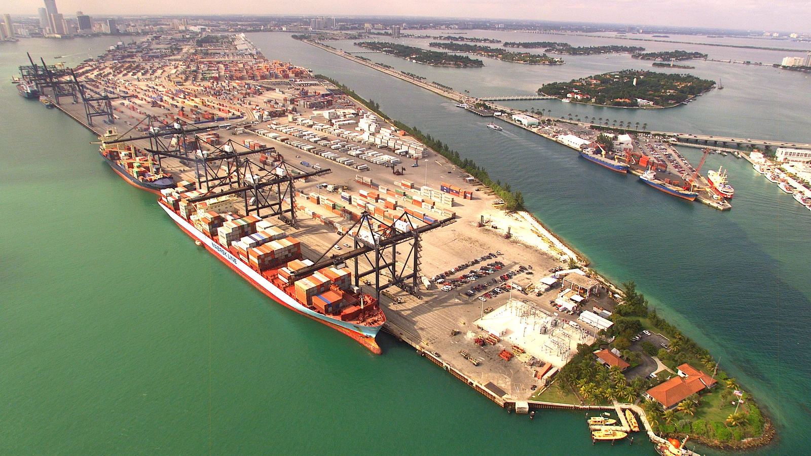 Aerial view of a US container port with ships at the cranes and stacked boxes on the quay