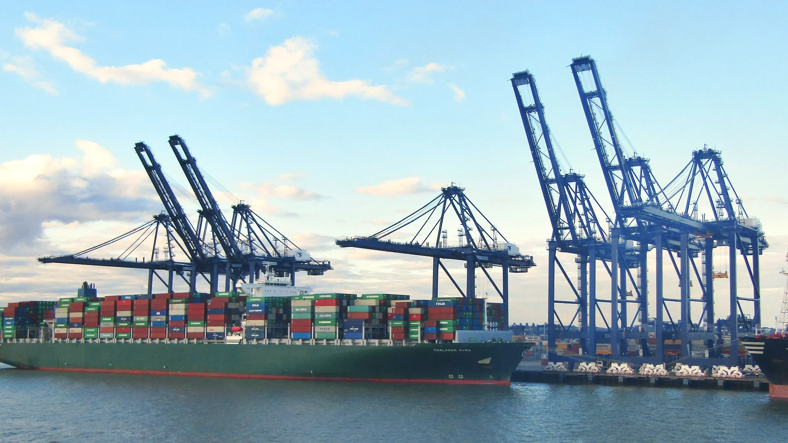 Container ship berthed under blue gantry cranes at the Port of Felixstowe