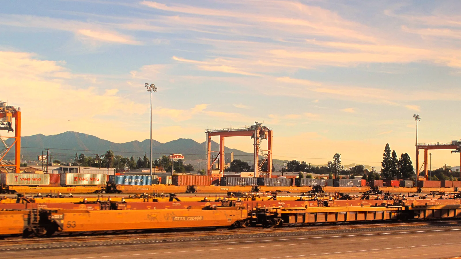 Straddle carriers over rail cars at an intermodal container yard in Los Angeles