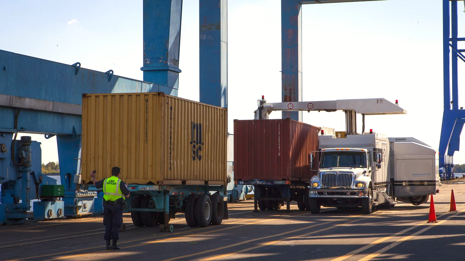 Customs officers run a non-intrusive X-ray scan on a container truck at a port